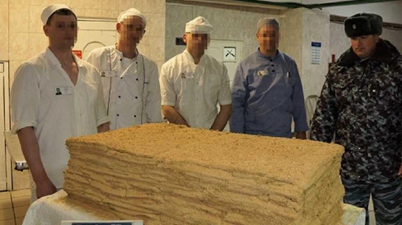 Крупный план аппетитного торта весом 101 кг, украшенного изысканными элементами, символизирующего грандиозное событие.