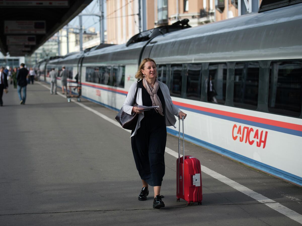 Повара в униформе готовят еду в вагоне-ресторане поезда, демонстрируя мастерство и рекорд.