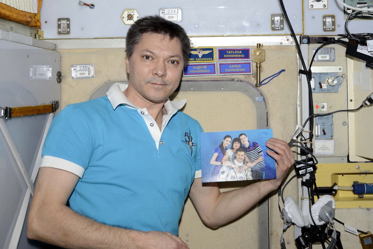 Фотография космонавта Олега Кононенко в скафандре на фоне Земли