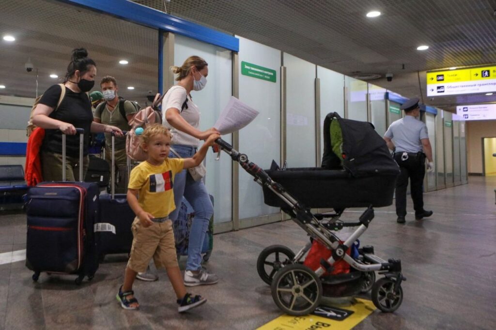 Сцена в аэропорту с отцом и ребенком, готовящимися к посадке, окруженные чемоданами