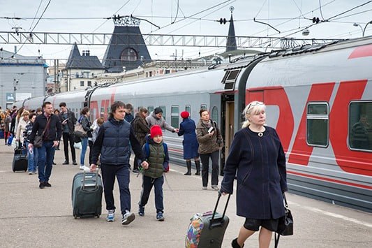Пассажир улыбается, проходя через турникет в поезде РЖД с системой распознавания лиц