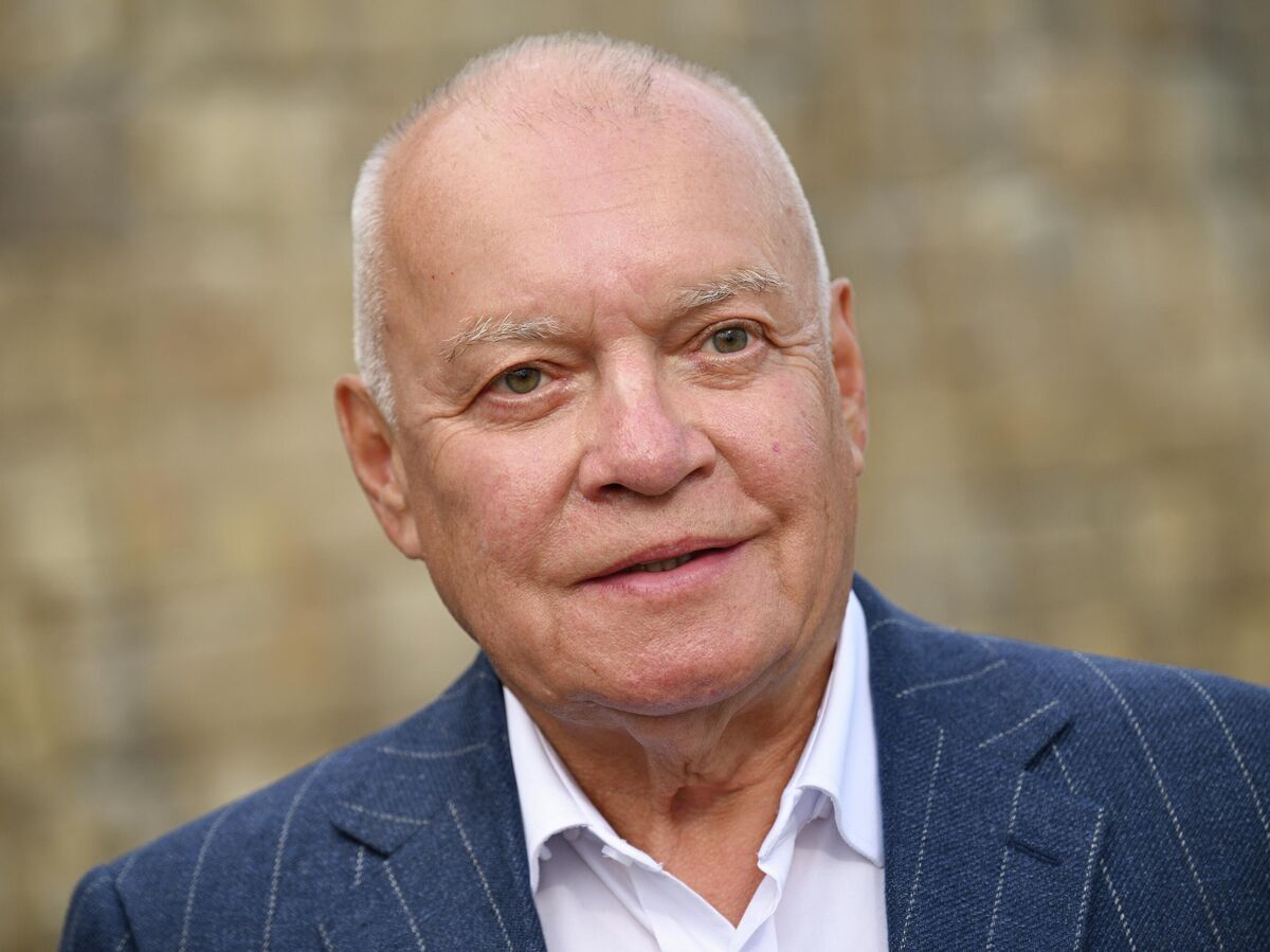 Дмитрий Киселев, ведущий, благословляет музыкантов русского джаза на фоне колокольни.