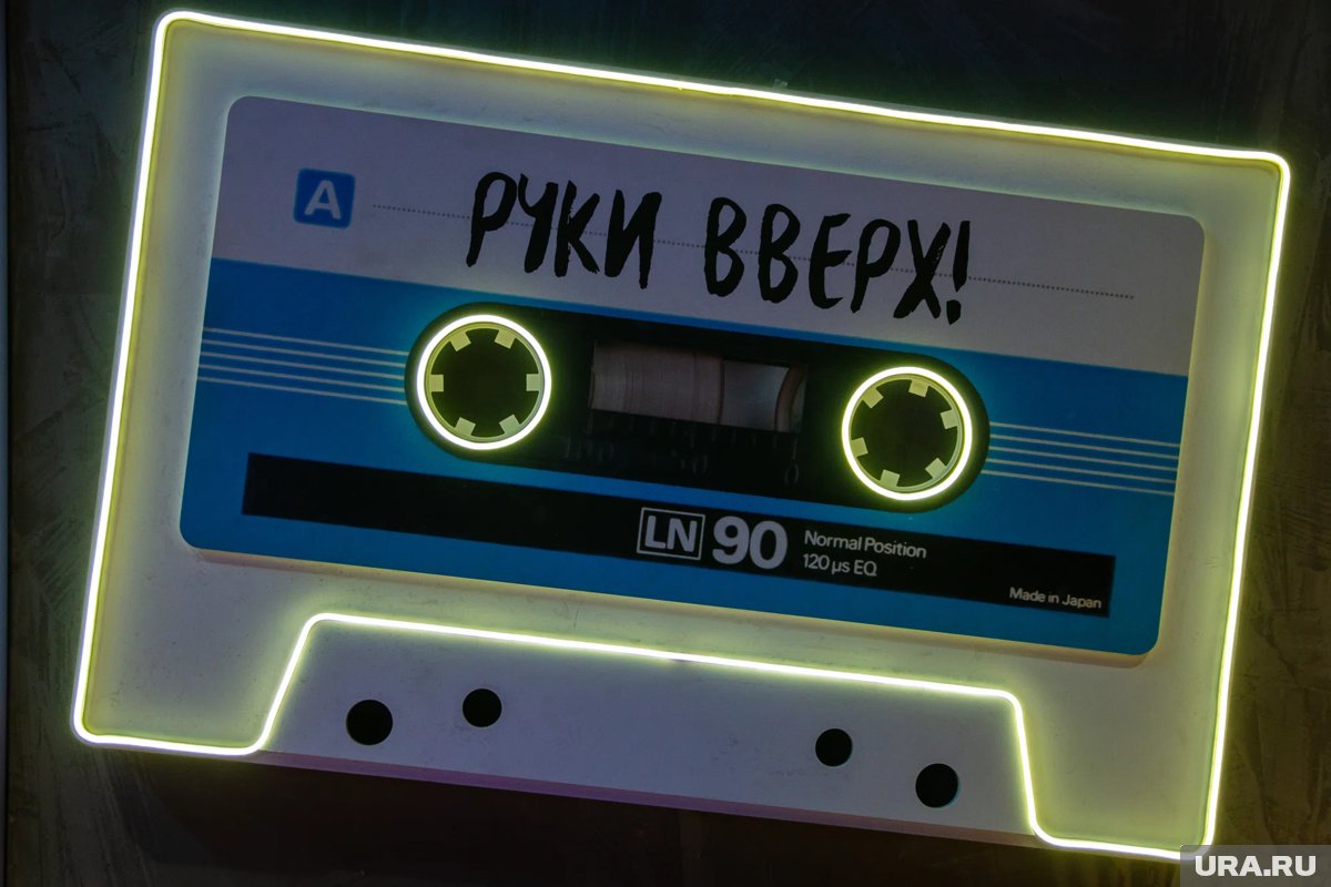 Логотип группы 'Руки вверх!' на фоне кассеты и музыкальных нот.