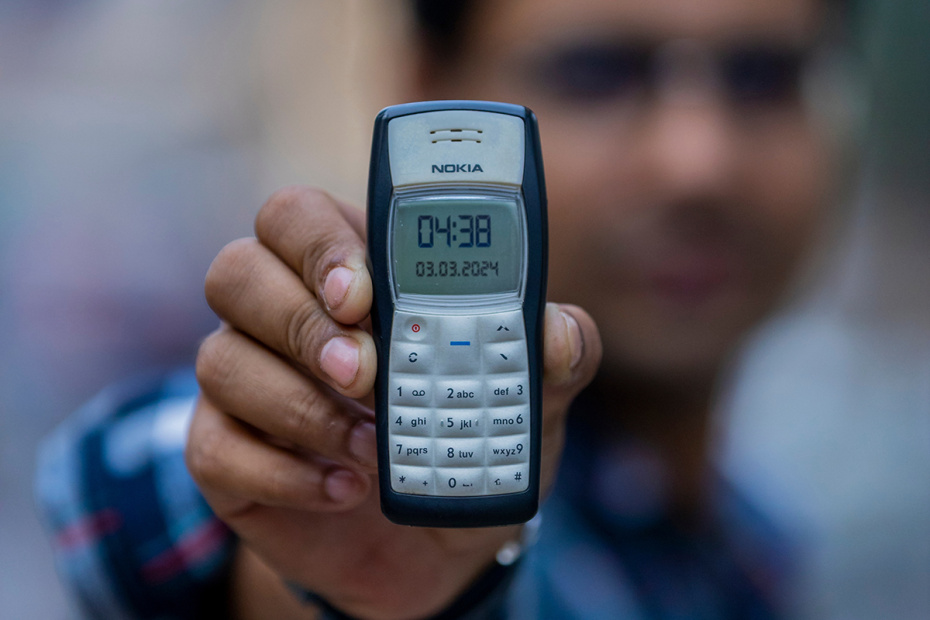Изображение Nokia 1100 на фоне современных смартфонов