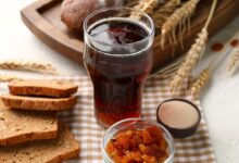 Квас в стакане с хлебом и зерном на фоне