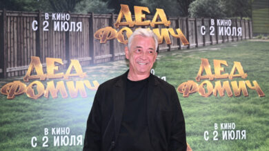 Николай Добрынин на фоне экранов с миллионами просмотров