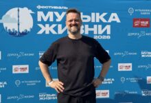 Изображение кожаного музыканта с гитарой на фоне машин