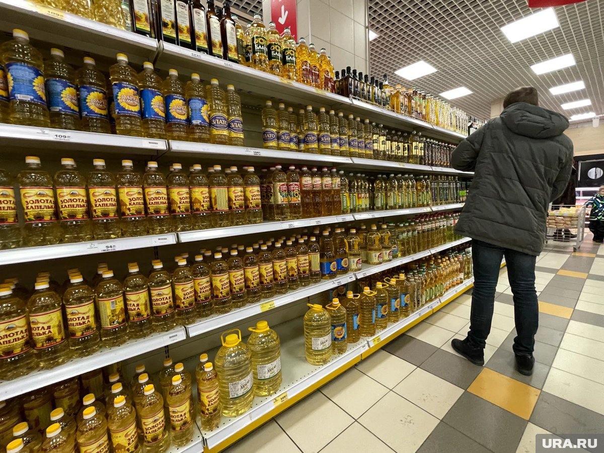 Картинка с подсолнечным маслом и кухонными принадлежностями, иллюстрирующая способы очистки масла.