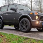 LADA Niva с табуном лошадей на фоне автосалона