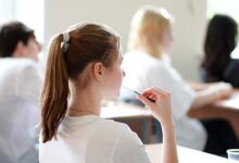 Ученики в классе с радостными выражениями лиц, обсуждающие новые учебные подходы.