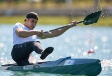 Захар Петров демонстрирует бронзовую медаль с золотым отливом на чемпионате мира по гребле