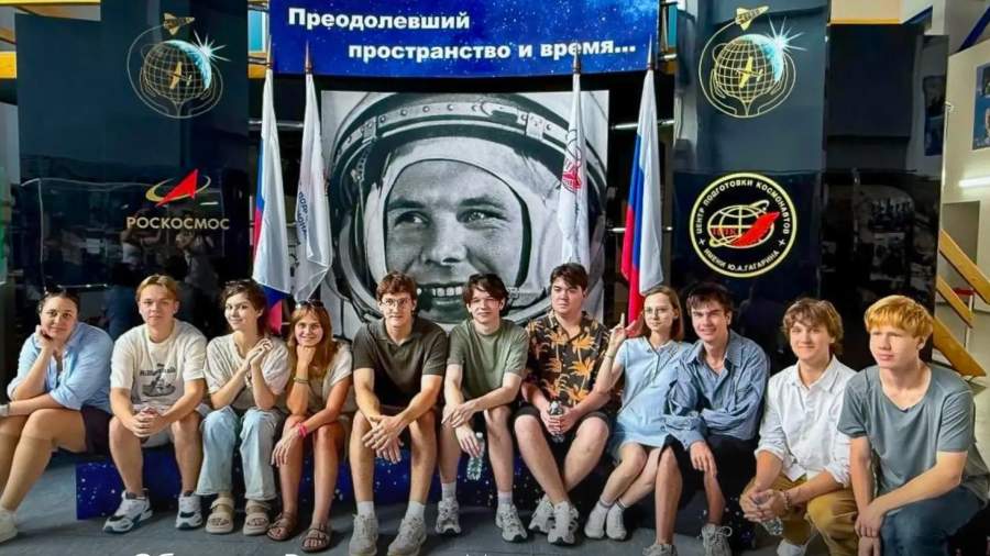 Российские школьники с кубком в руках на фоне модели города в поясе астероидов