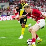 16-летний школьник с мячом и бутсами на фоне Спартака