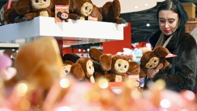 Чебурашка с юбилейным тортом на фоне праздничной атмосферы