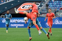 Изображение матча между командой «Родина» и петербургскими грандами с футбольным мячом на поле.