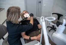 Стоматолог с недоумением смотрит на пациента, на фоне новостей о запрете проверок