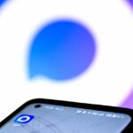 Изображение мессенджера MAX на экране iPhone с яблоками в фоне