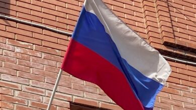 Спортсмен выполняет удар ногой с разворота на фоне спортивного стадиона