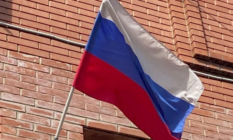 Спортсмен выполняет удар ногой с разворота на фоне спортивного стадиона