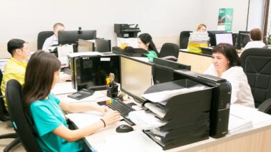 Мама на работе с документами Трудового кодекса, улыбающаяся и планирующая уходить пораньше