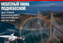 Дрон запечатлел радугу под мостом с небесным фоном.