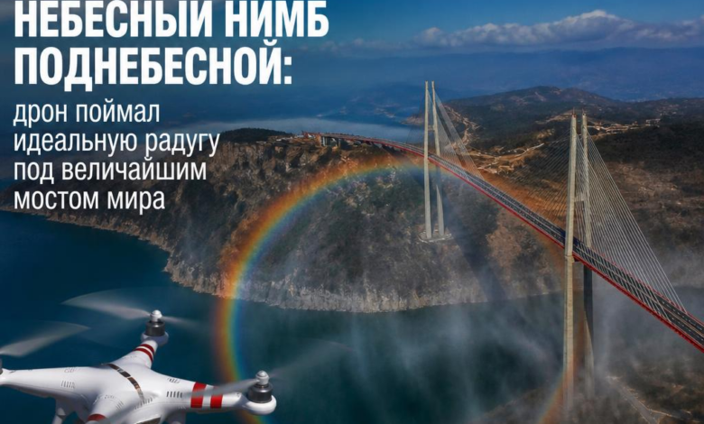 Дрон запечатлел радугу под мостом с небесным фоном.