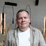 Тарелка борща с пельменями и аранчини на фоне туристических сувениров