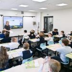 Современные школьники в новом интерьере класса с высокими технологиями