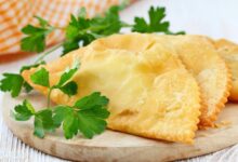 Чебурек, наполненный мясом, на фоне китайского пейзажа.