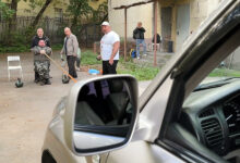 Мужчина в лабораторной одежде демонстрирует силу, унося внедорожник