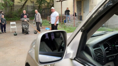 Мужчина в лабораторной одежде демонстрирует силу, унося внедорожник