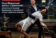 Медведев празднует победу в Нью-Йорке, рядом с ракеткой и трофеем.