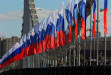 Российские фигуристы выступают на льду в Токио, поднимая триколор