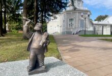 Бронзовые фигурки пензяков на фоне городской архитектуры