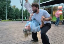 Молодая женщина в пышной юбке и с кокой набекрень, наслаждающаяся осенним днем в Москве.
