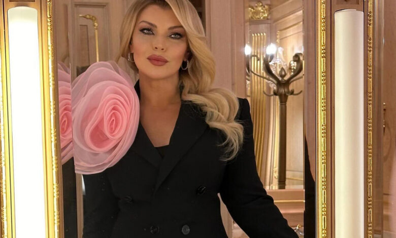Лада Дэнс в малиновом пиджаке на фоне кассет