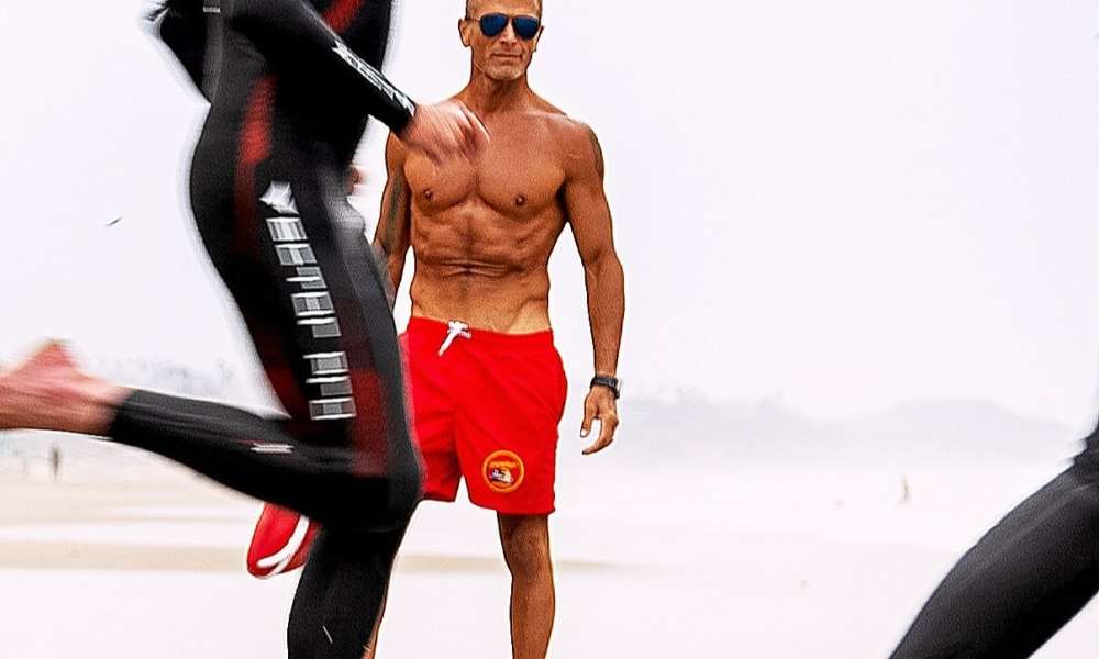 Актеры из сериала Baywatch, включая исполнителя роли Зеленой Стрелы, в красных плавках и с куриными крылышками