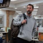 Ноа Уайли в медицинском халате с стетоскопом на фоне зимнего Питтсбурга