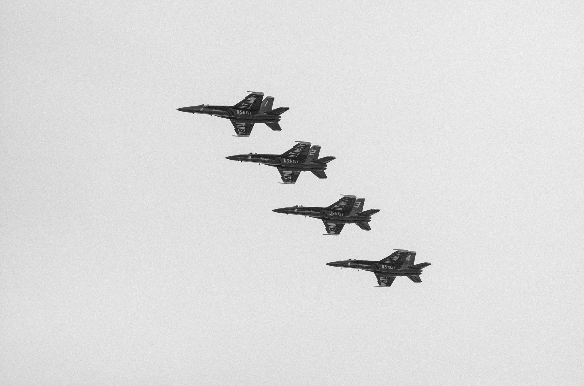 Four Blue Angles jets flying in formation.