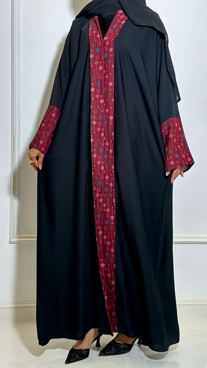 عباية سوداء بتفاصيل حمراء عصرية